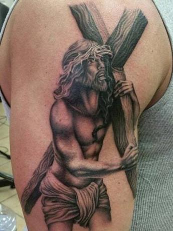 Le tatouage de Jésus portant une croix