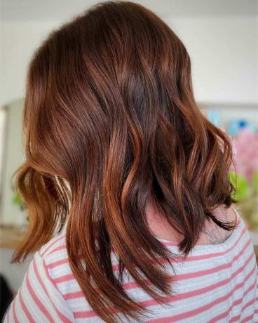 Un taglio di capelli corto giocoso con il colore dei capelli ramati per capelli spessi
