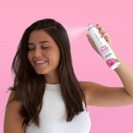 Kvinde, der bruger tør shampoo til at opfriske hår