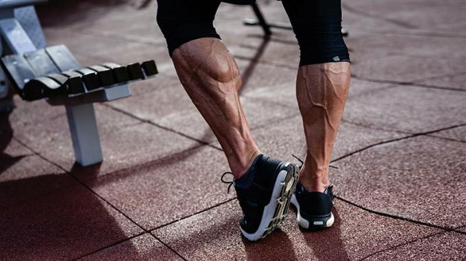गर्मियों में आउटडोर प्रशिक्षण कसरत स्पोर्ट स्ट्रीट जिम में स्नीकर्स में आदमी के मजबूत एथलीट सक्रिय पैर