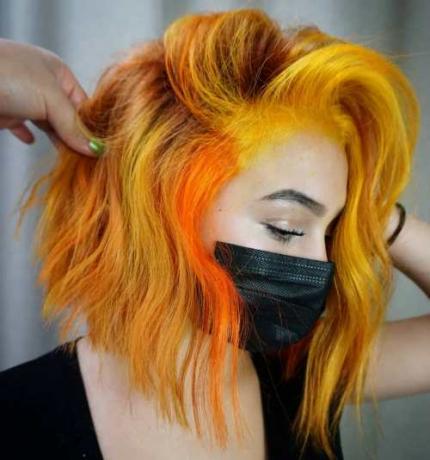Luonnolliset punaiset hiukset keltaisilla ja oranssilla kohokohdilla