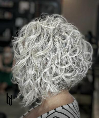 Păr creț alb metalic într-o tunsoare scurtă stivuită