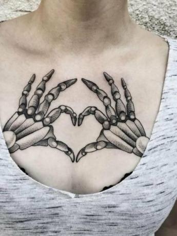 Kostrové ruky, ktoré robia tetovanie srdca
