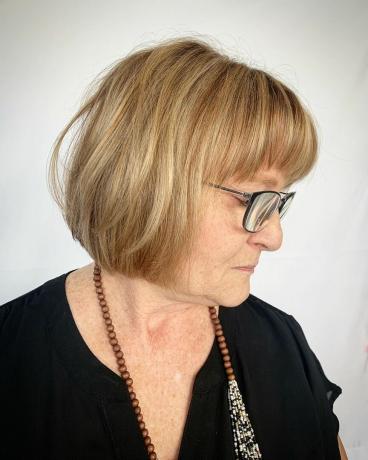 Duga Bob frizura za starije žene iznad pedeset godina s naočalama i okruglim licem