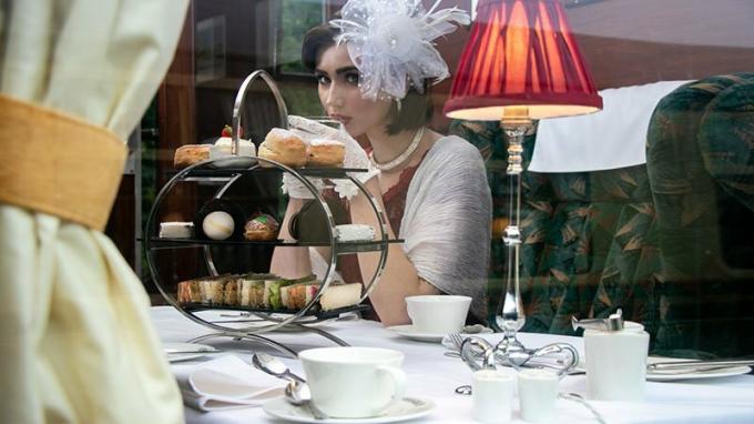 Belle femme en vêtements vintage, appréciant le thé de l'après-midi en train