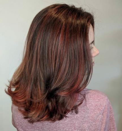 Destaques de vermelho acastanhado em cabelo preto natural