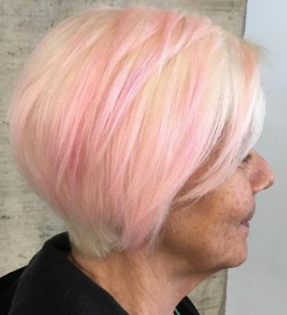 Bob en capas con flequillo y tono rosa en mujer mayor de 60 años