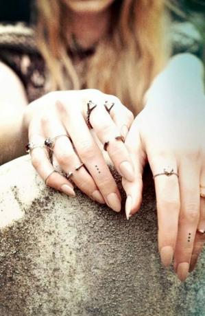 Tatuaggio con puntini sulle dita